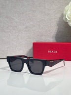 Prada glasses with dark frame and red accents on temple, with red case