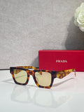 Prada glasses with tortoiseshell frame and amber tinted lenses, with red case