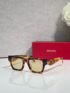 Prada glasses with tortoiseshell frame and amber tinted lenses, with red case