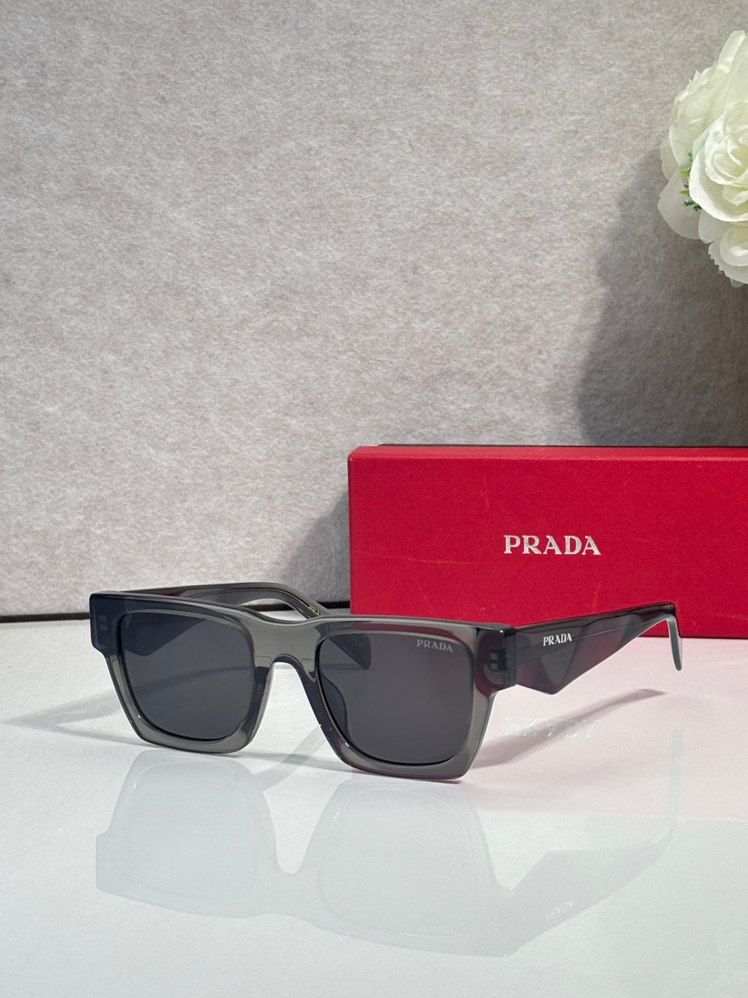 Prada glasses with dark frame and smoke lenses, with red case