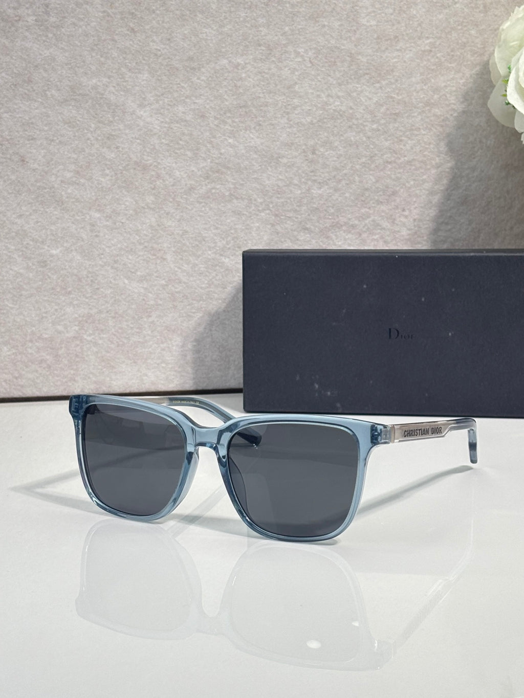 Sunglasses with teal-blue frame and dark tinted lenses.