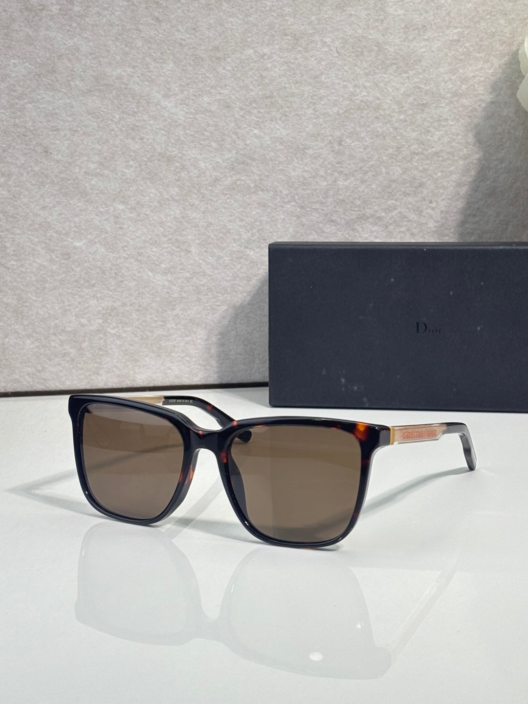 Sunglasses with dark blue frame and warm brown tinted lenses.