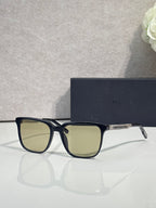 Sunglasses with black frame and light green tinted lenses.