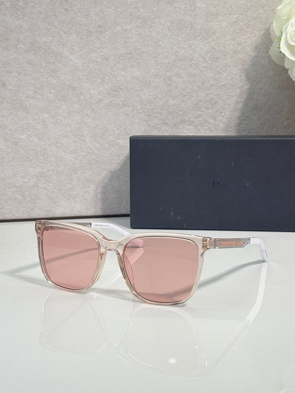 Sunglasses with clear pink frame and pink tinted lenses.