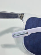 Dior glasses close-up of white temple with metal detail and blue lens