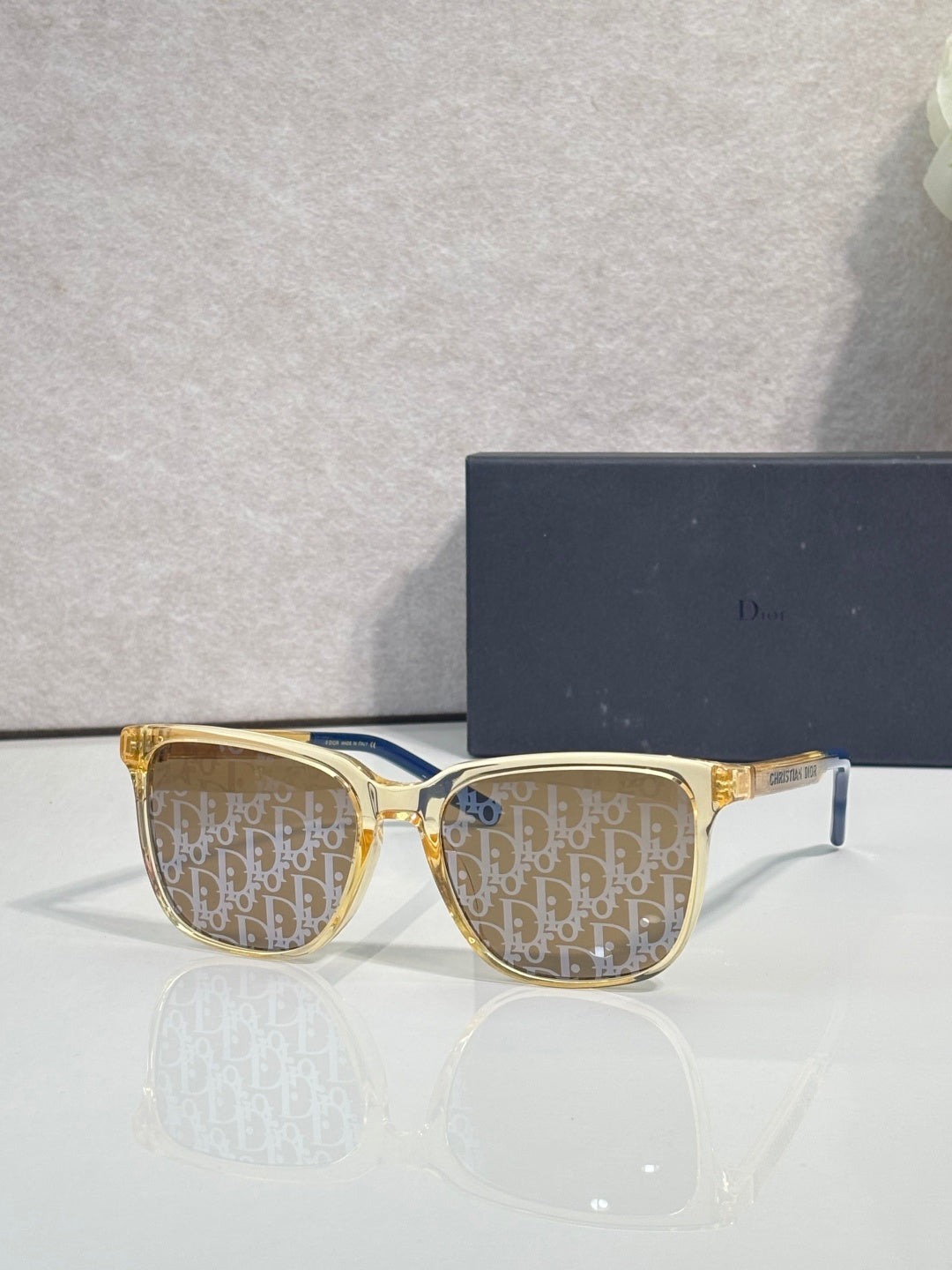 Dior glasses with gold frames and brown monogram-pattern lenses