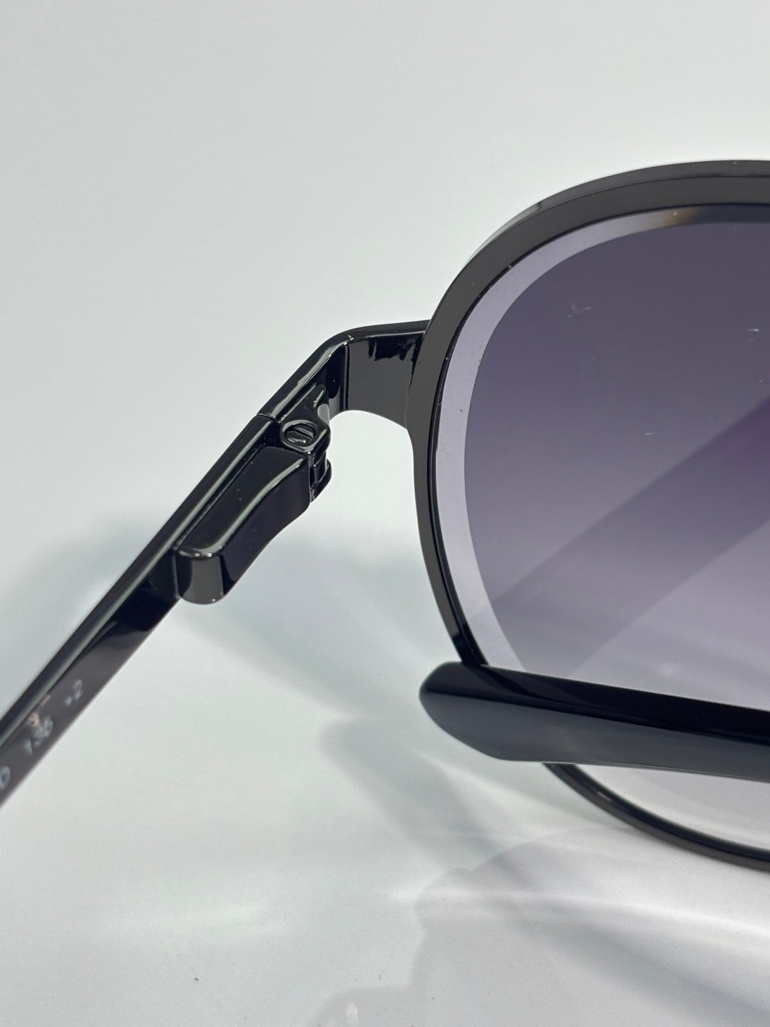 Sunglasses side view with dark blue frame and hinge detail, dark tinted lenses