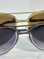 Sunglasses close-up with gold round frames and dark tinted lenses