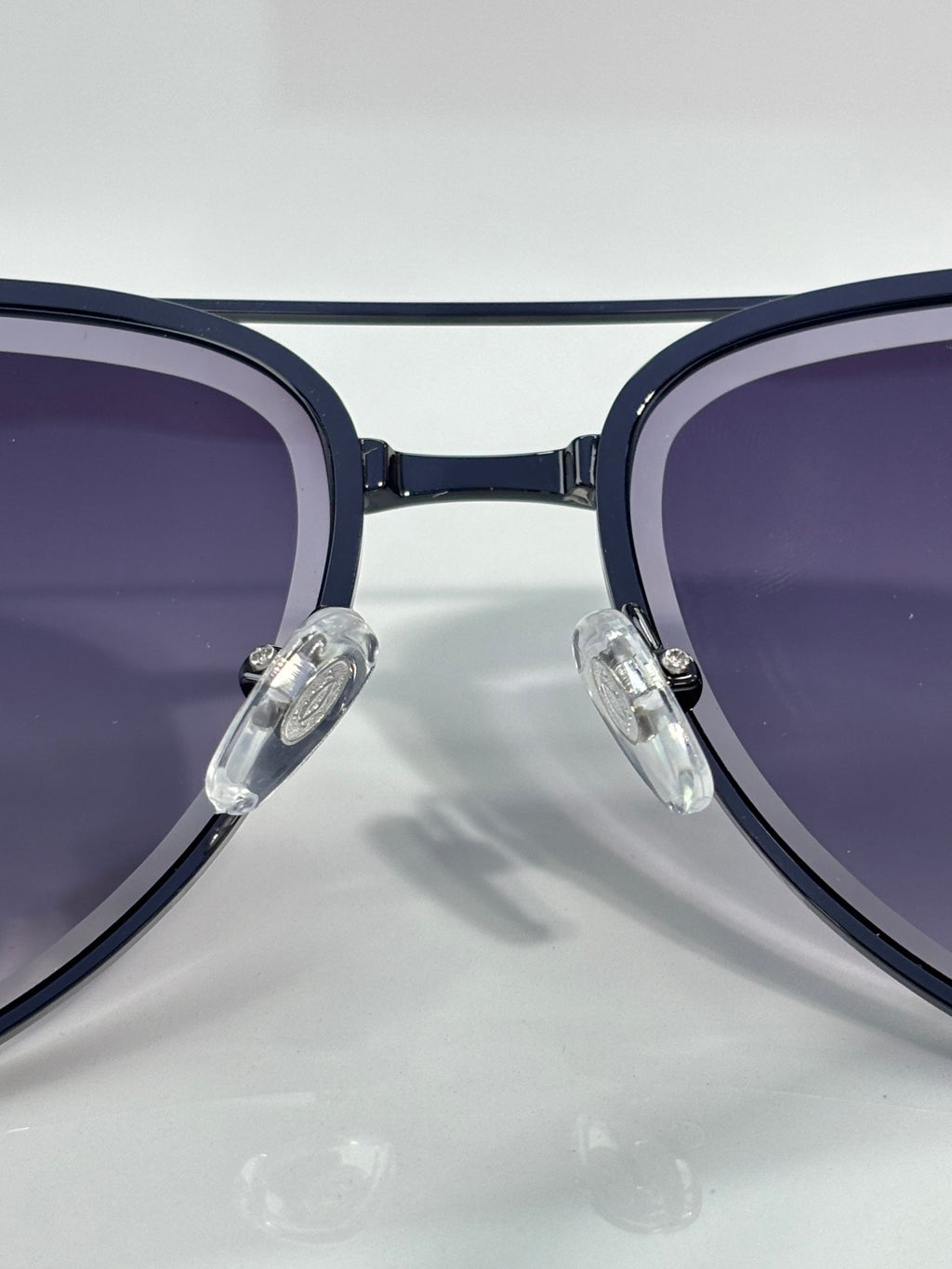 Sunglasses close-up with dark blue round frames and purple-tinted lenses