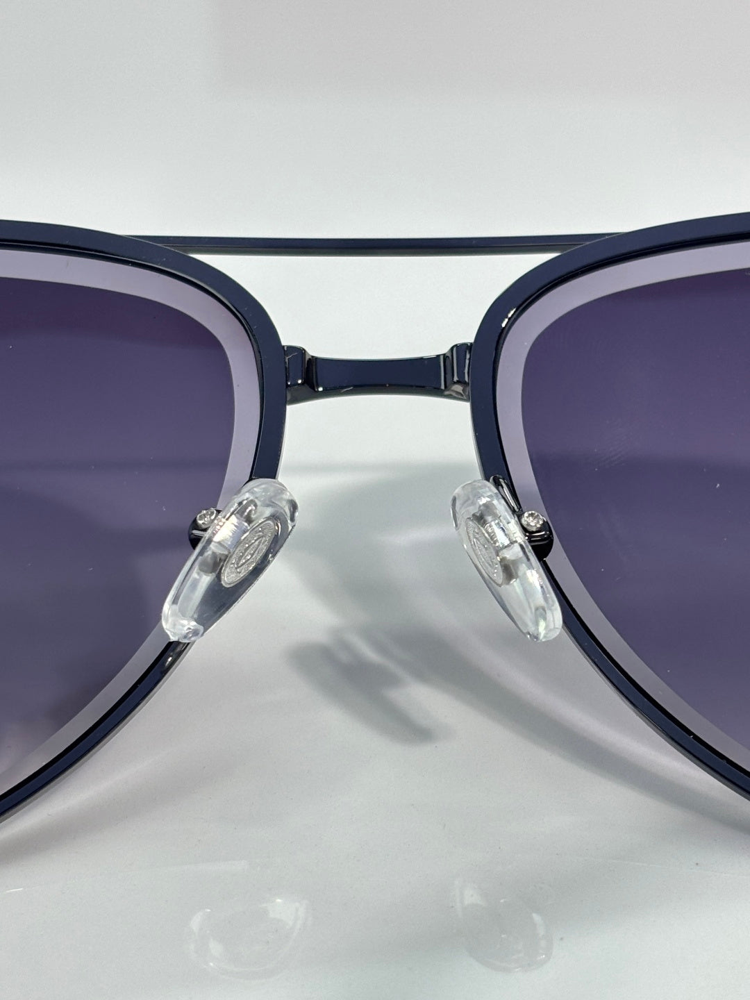 Sunglasses close-up with dark blue round frames and purple-tinted lenses