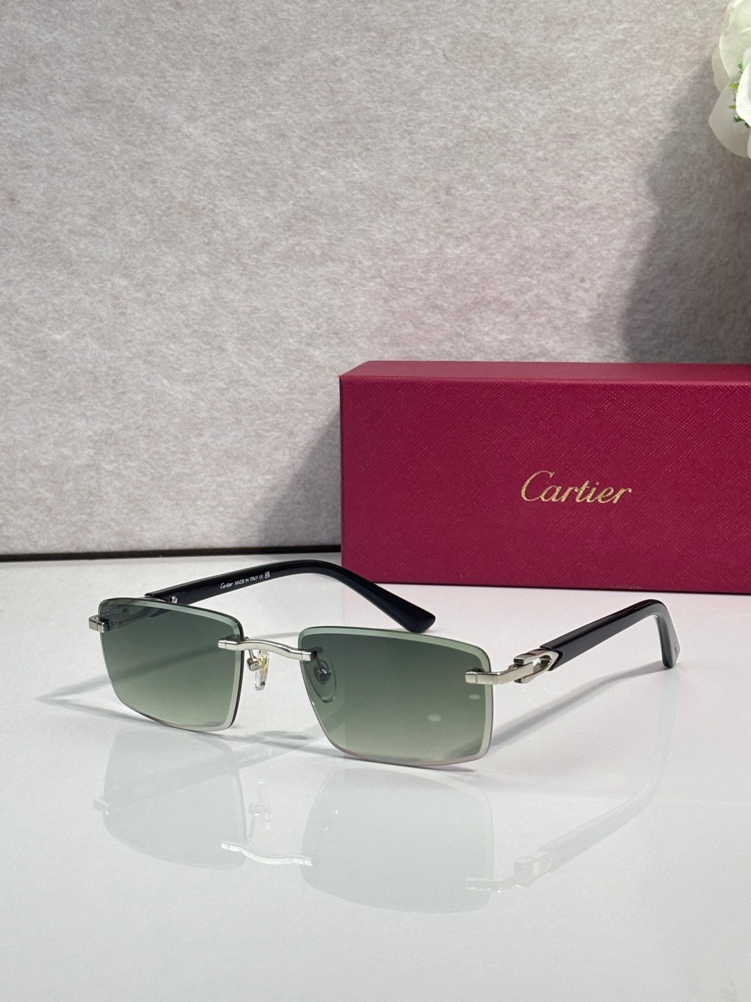 Gold sunglasses with green-tinted square lenses and dark temple tips