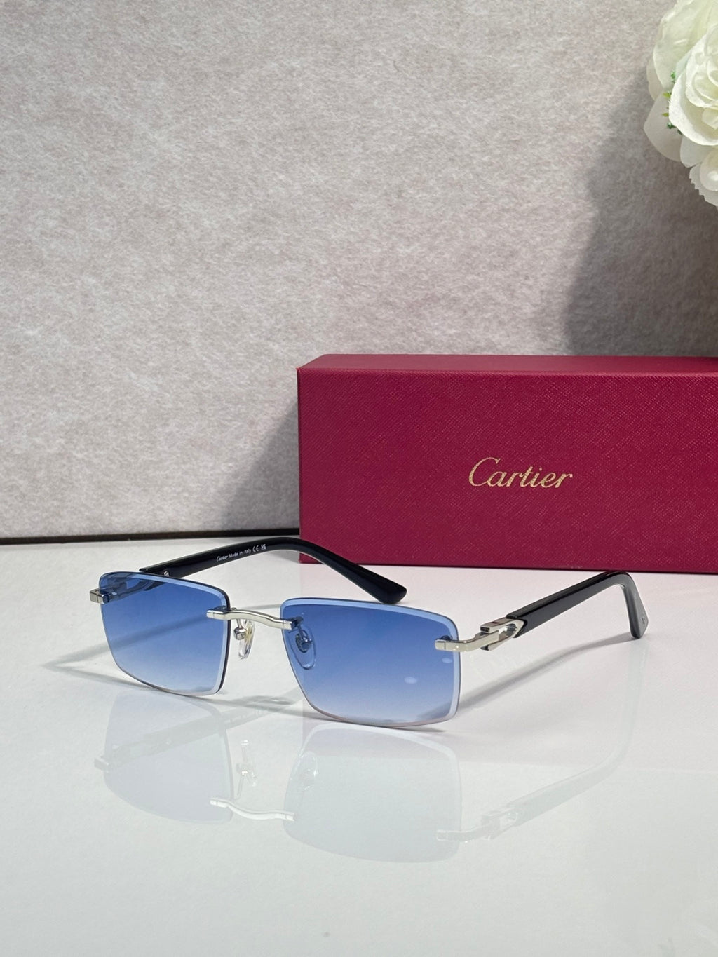 Gold sunglasses with light blue square lenses and blue temple arms