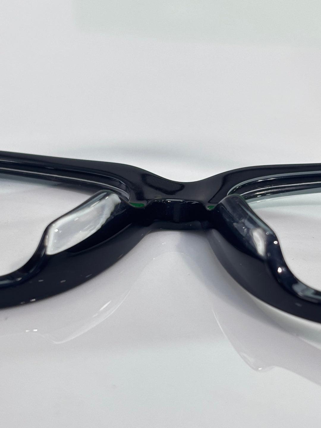 Bottega Veneta eyeglasses close-up, dark glossy frame with clear lenses