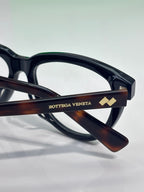 Bottega Veneta eyeglasses temple close-up, tortoise arm with logo detail