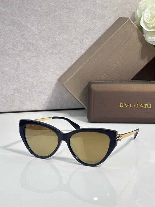 Black cat-eye sunglasses with warm tinted lenses and gold-tone temple accents.