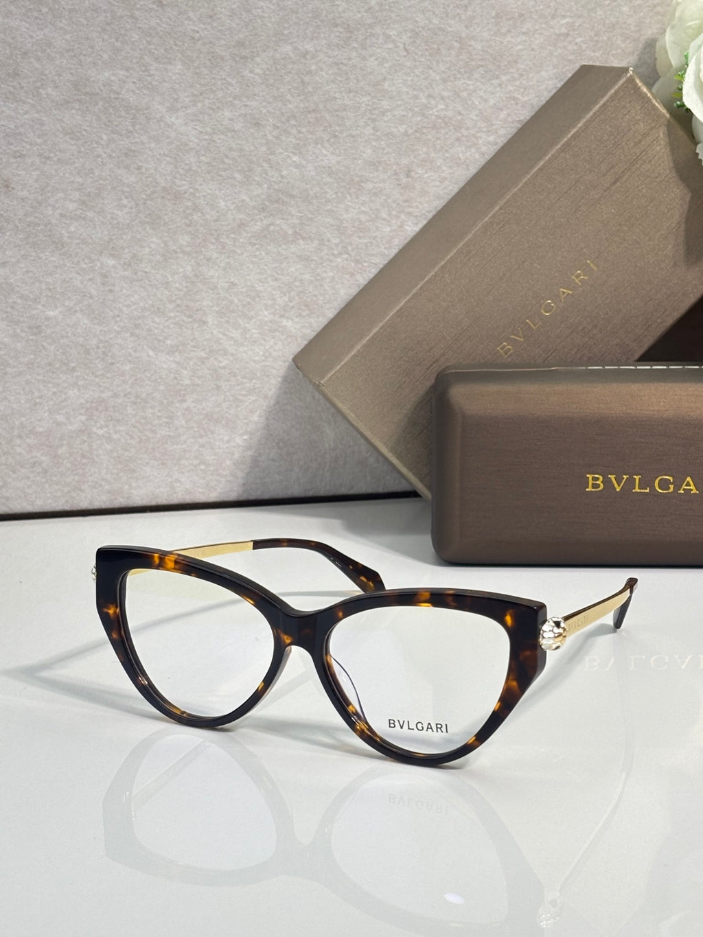 Tortoise cat-eye eyeglasses with clear lenses and gold-tone temple accents.
