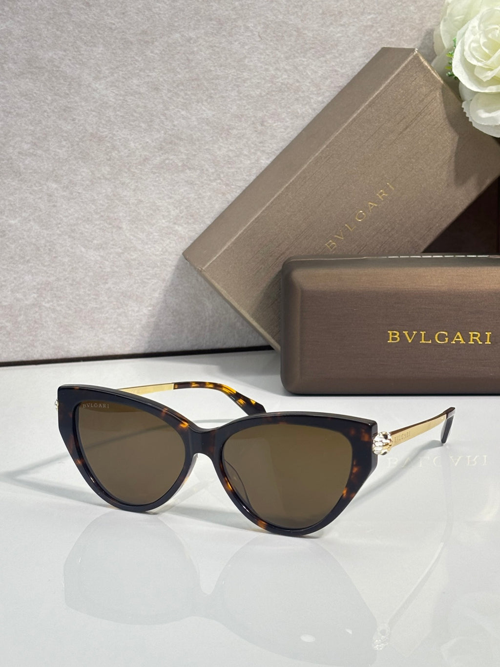 Tortoise cat-eye sunglasses with dark tinted lenses and gold-tone temple accents.