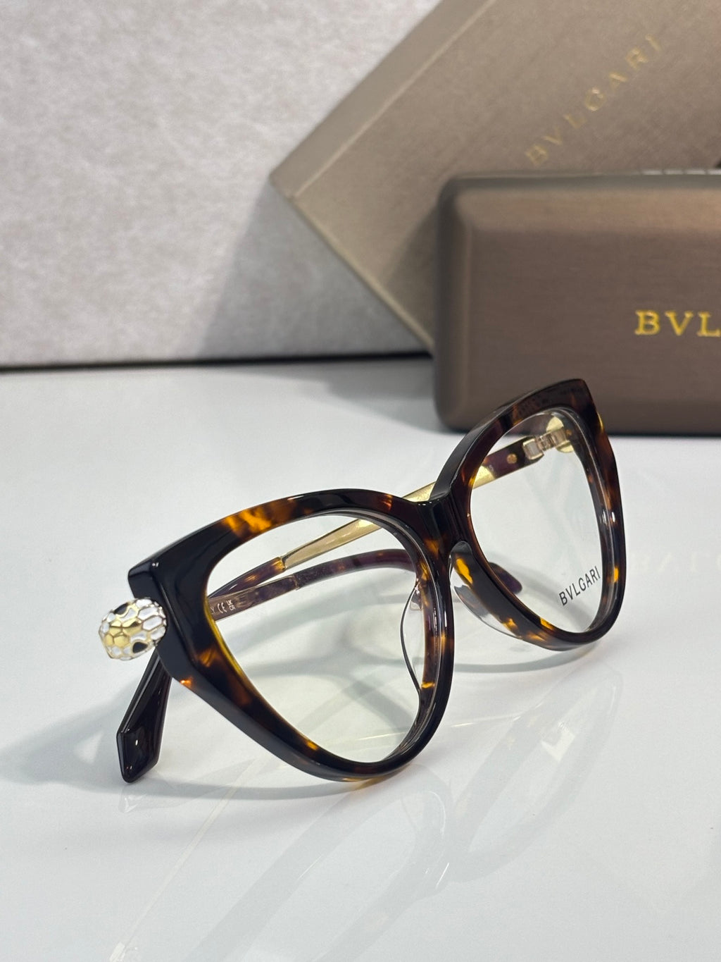 Tortoise cat-eye eyeglasses with clear lenses and decorative gold-tone detail.
