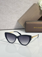Black cat-eye sunglasses with dark tinted lenses and gold-tone temple accents.
