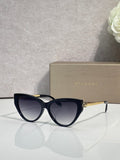 Cat-eye sunglasses with dark navy frames and gold temple detailing, tinted lenses