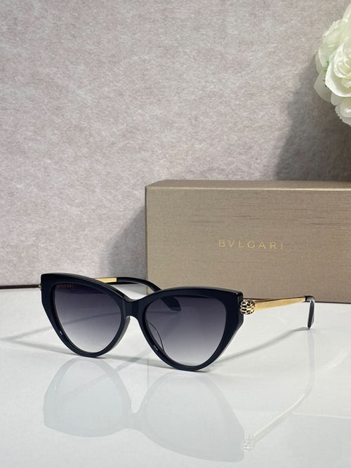 Cat-eye sunglasses with dark navy frames and gold temple detailing, tinted lenses
