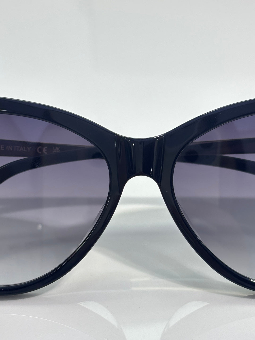 Front view of cat-eye sunglasses with dark navy frames and tinted gradient lenses