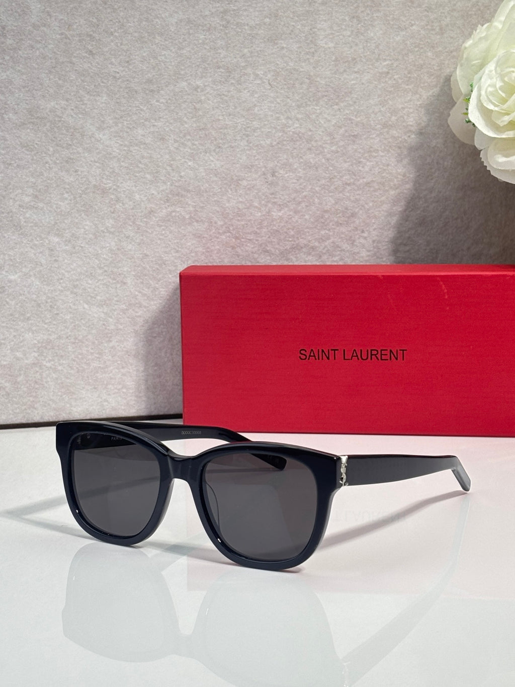 Saint Laurent eyeglasses with dark lenses, black frame, and gold logo accents