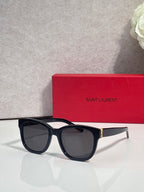 Saint Laurent eyeglasses with dark lenses and black frame, gold logo detail on arm