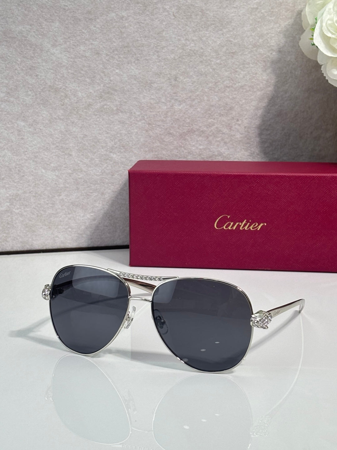 Cartier sunglasses with deep navy tinted lenses and silver-tone cat-eye frames, side detail
