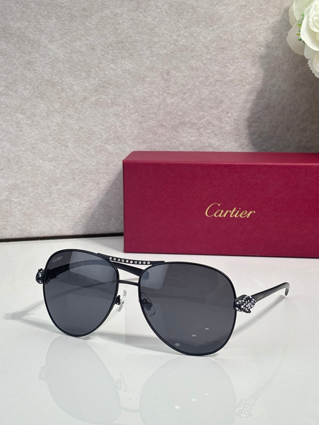 Cartier sunglasses with deep navy tinted lenses and silver-tone cat-eye frames, side detail