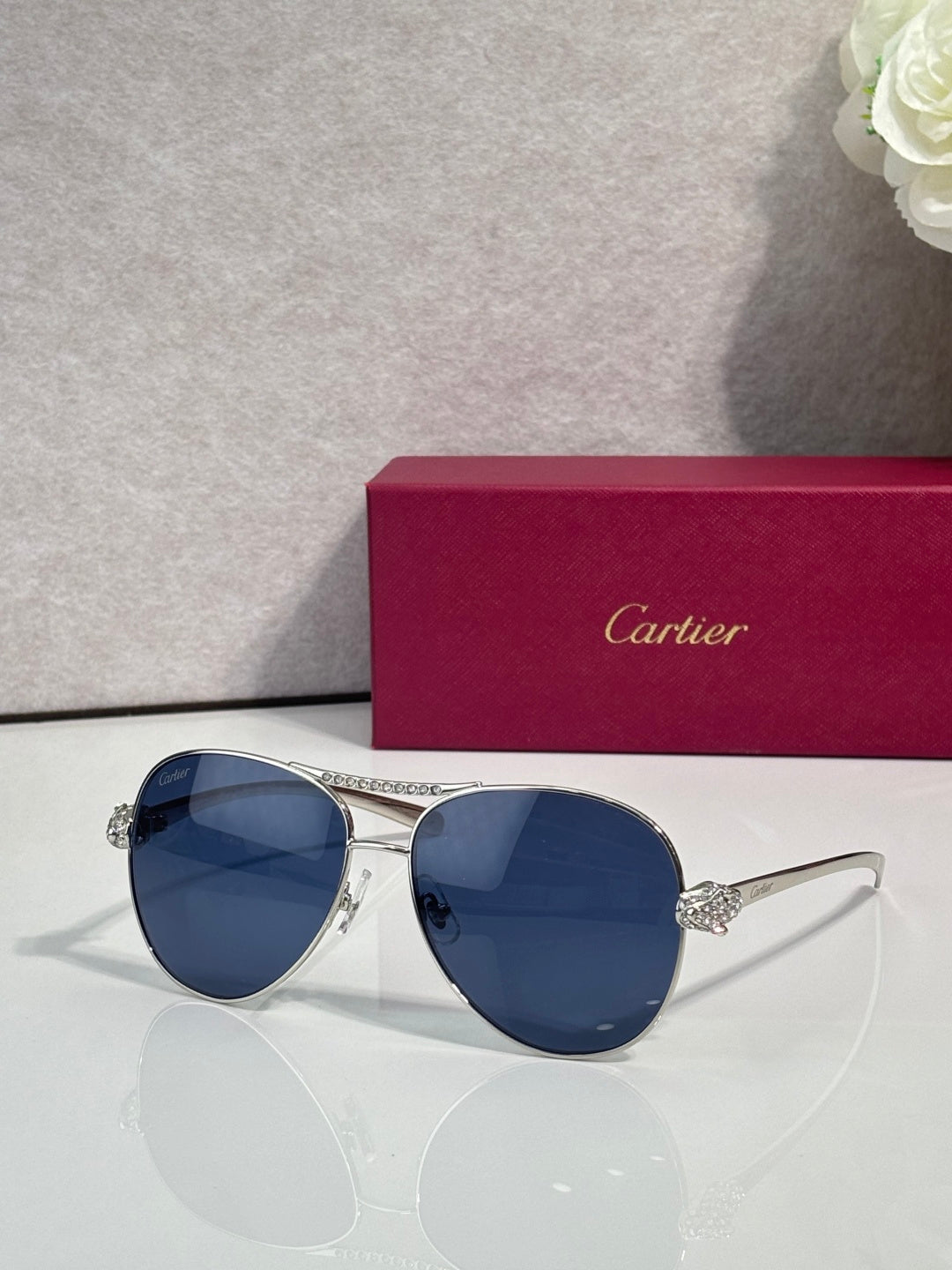 Cartier sunglasses with blue tinted lenses and silver-tone cat-eye frames, side detail