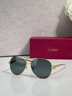 Cartier sunglasses with dark teal tinted lenses and gold-tone cat-eye frames, side detail