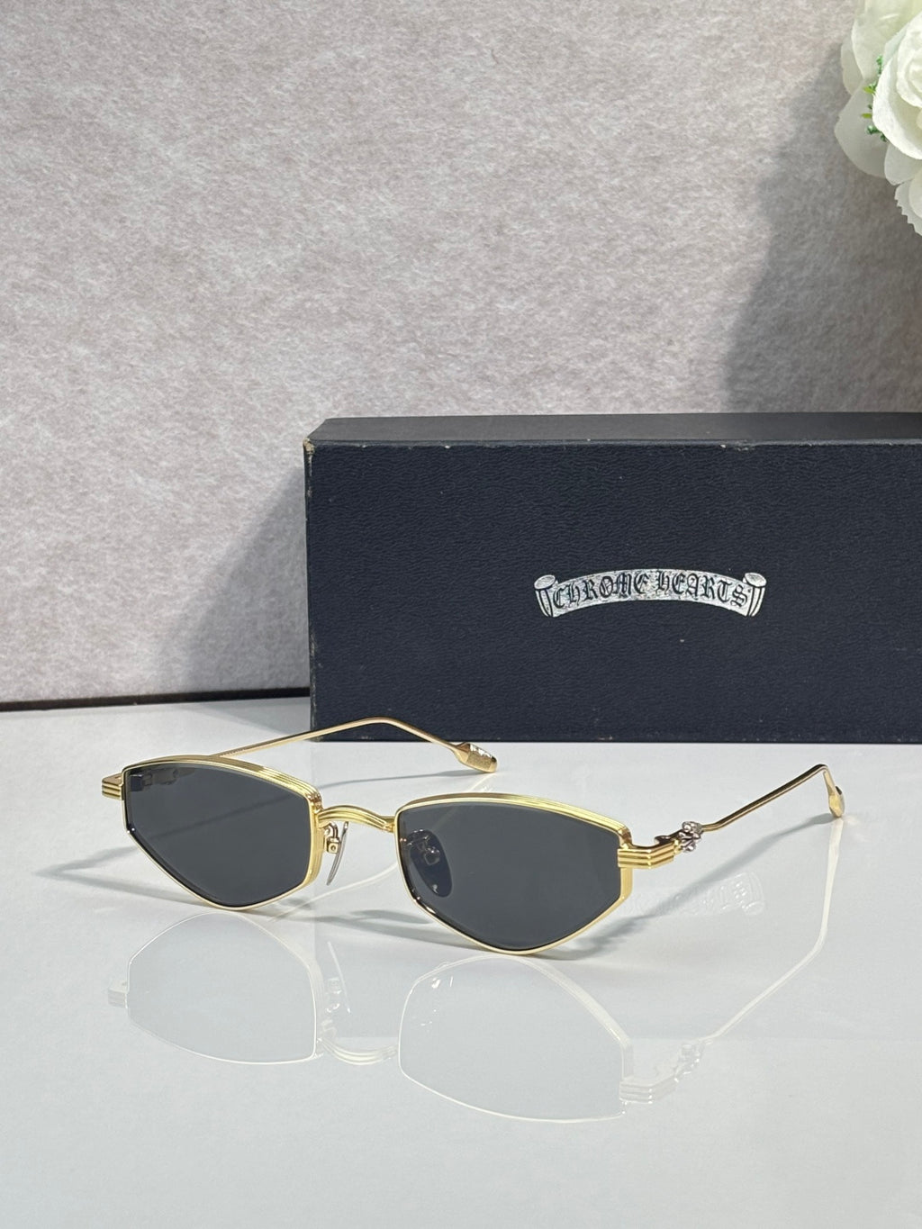 Gold-tone metal glasses with dark lenses and slender gold temples