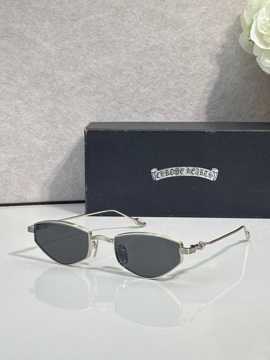 Gold-tone metal glasses with dark tinted lenses and curved clear bridge