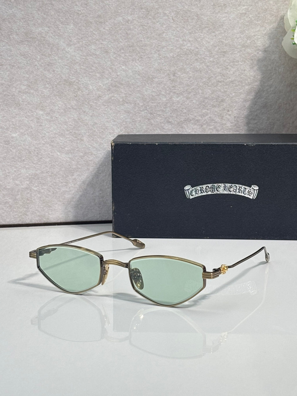 Gold-tone metal glasses with light green-tinted lenses and gold temples