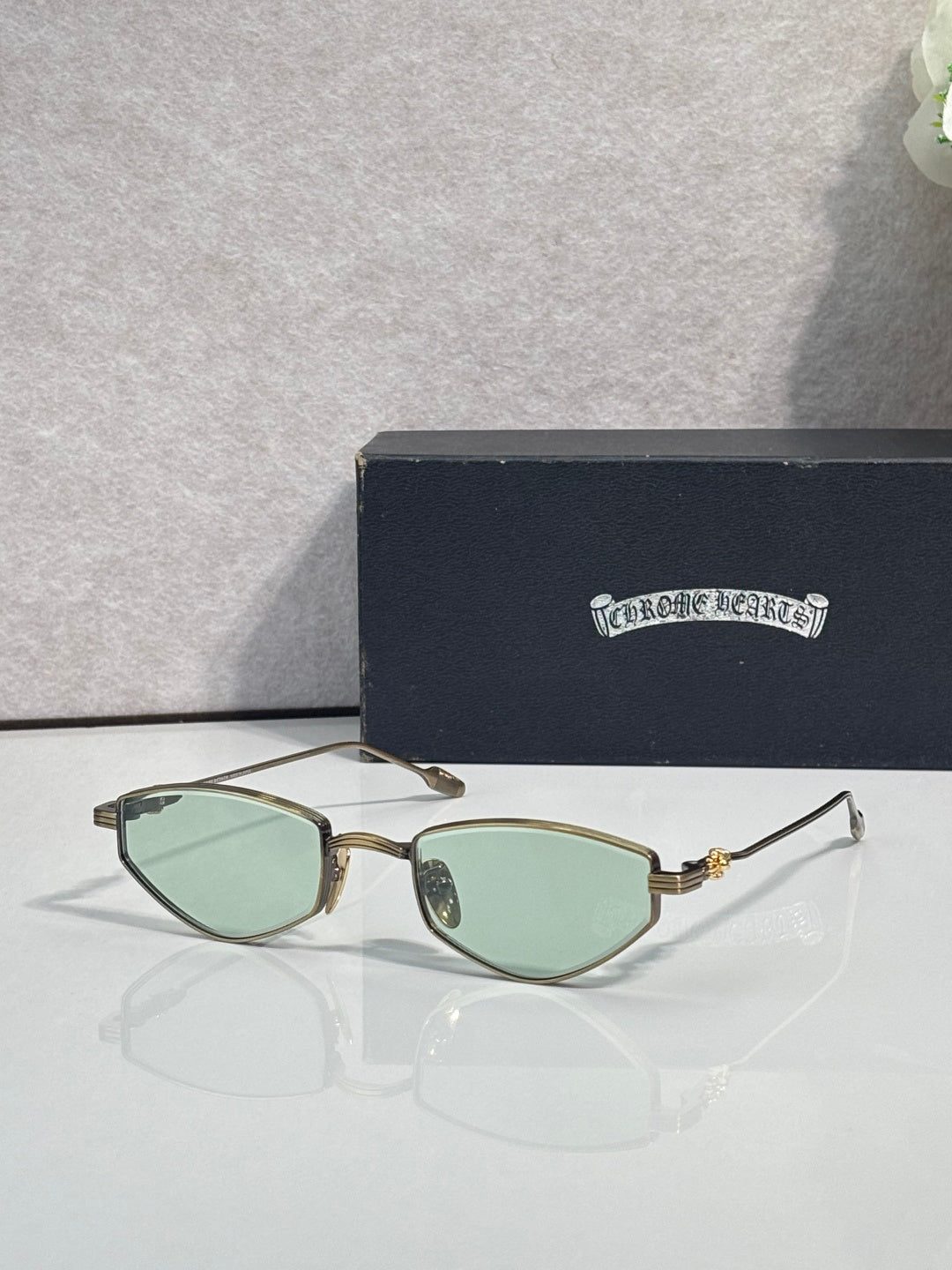 Gold-tone metal glasses with light green-tinted lenses and gold temples