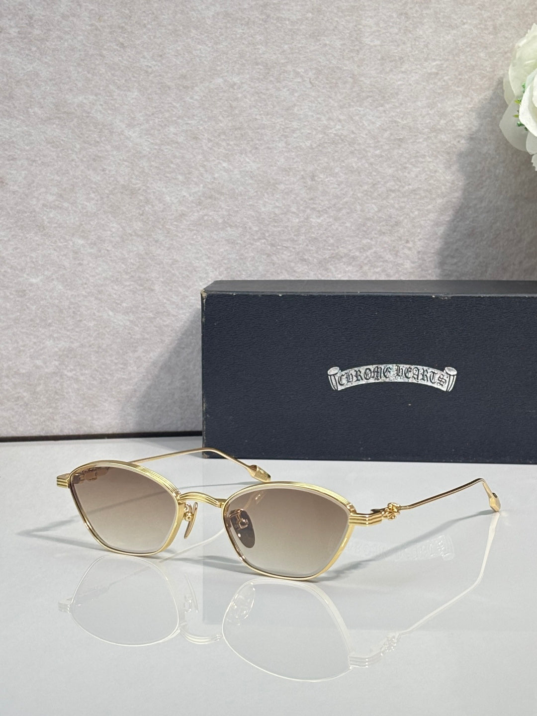 Gold metal frame eyeglasses with beige-tinted round lenses and clear temple tips