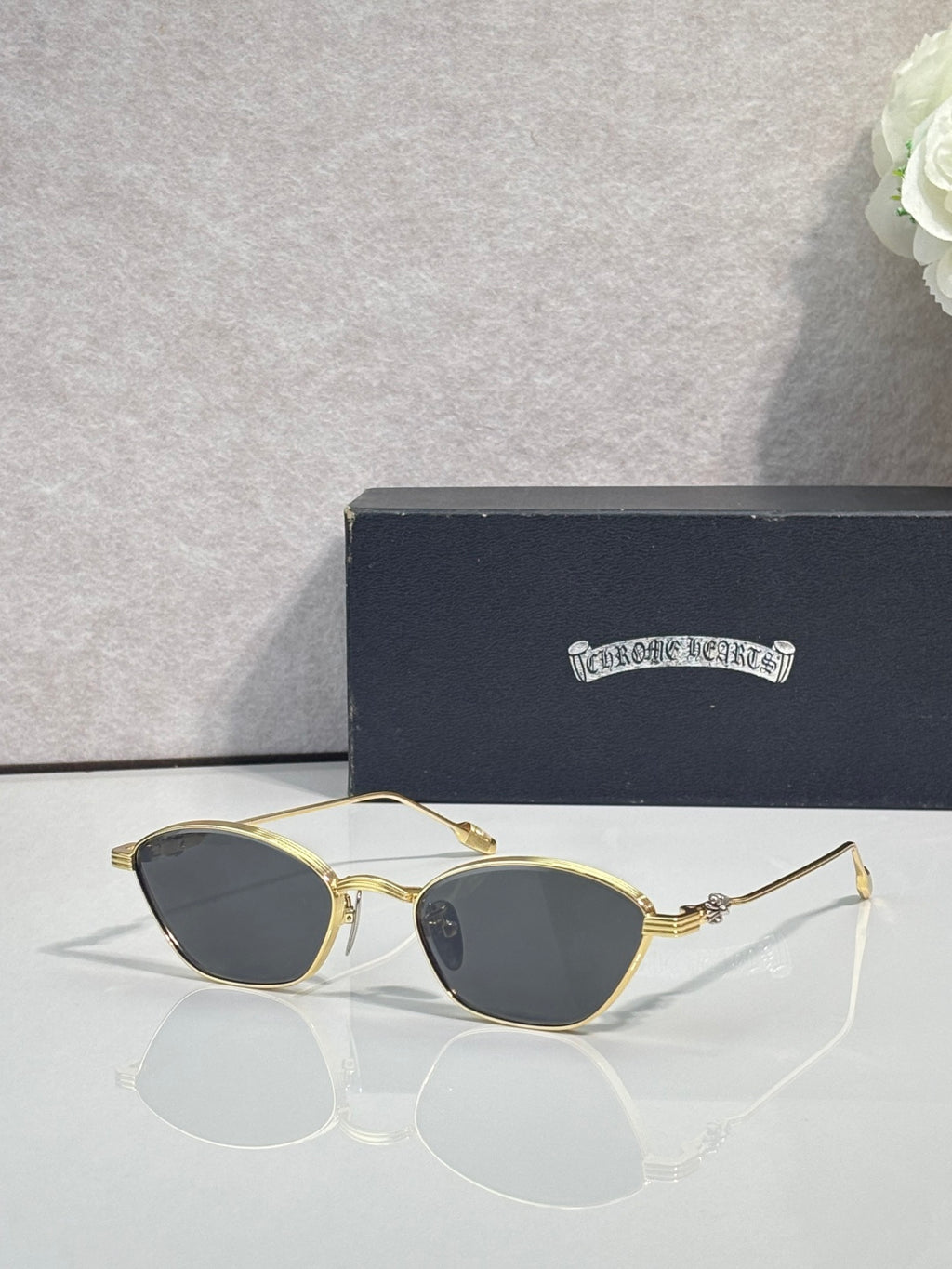 Gold metal frame sunglasses with gray-tinted round lenses and clear ear pieces