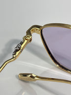 Gold temple hinge with small stones detail and purple-tinted lens edge