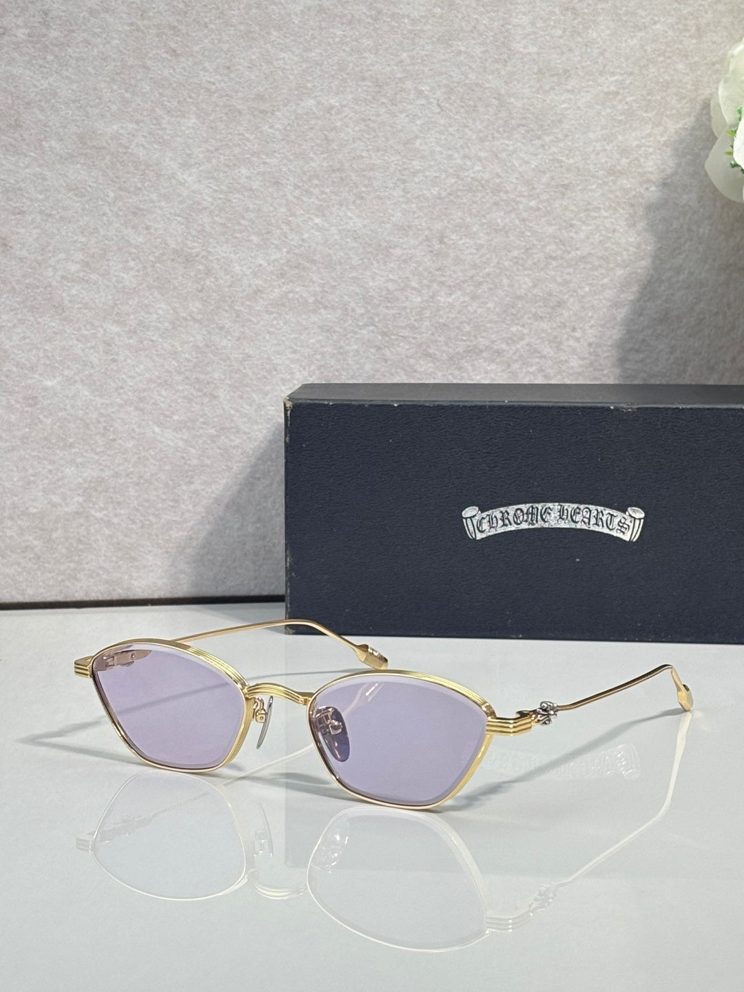 Gold metal frame eyeglasses with lavender-tinted round lenses and curved bridge