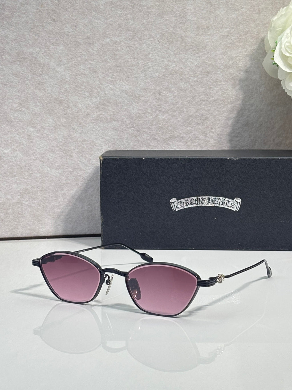 Black metal frame sunglasses with pink-tinted round lenses and gold-tone hinges