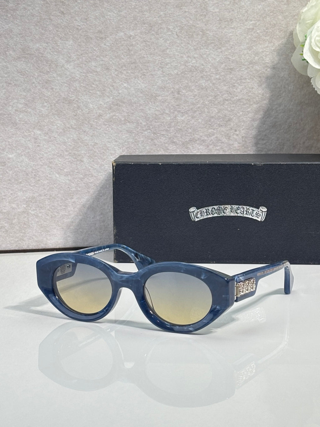 Navy round-frame glasses with tinted lenses and gold detail on temple