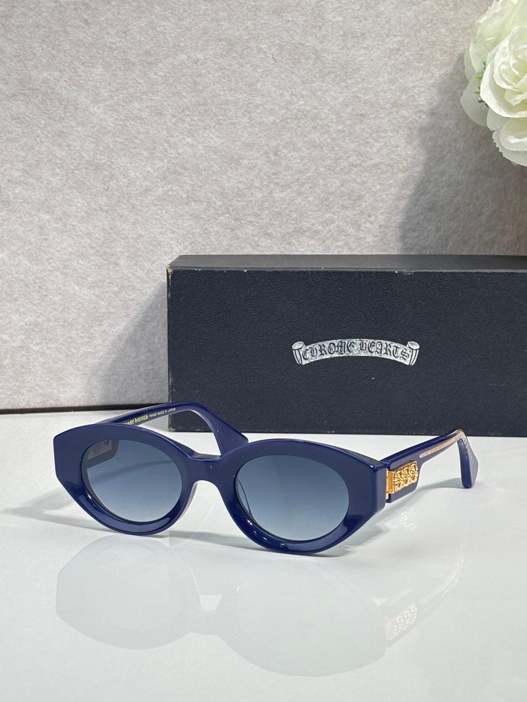 Blue round-frame glasses with tinted lenses and gold detail on temple