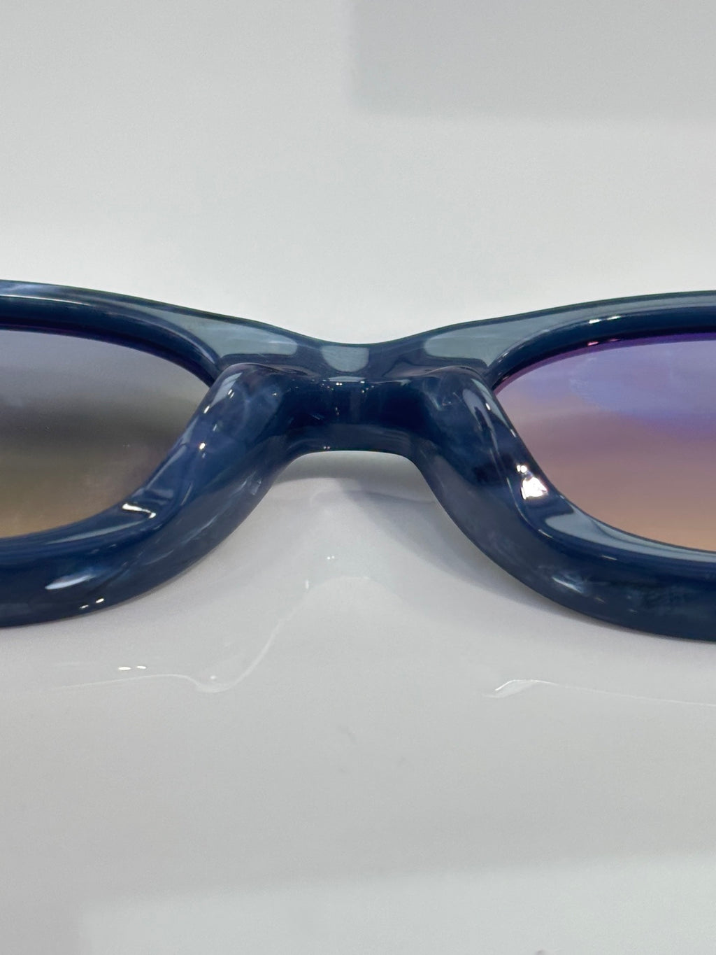Close-up of dark blue glossy round-frame glasses bridge and temples