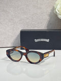 Tortoiseshell round-frame glasses with tinted lenses and gold detail on temple