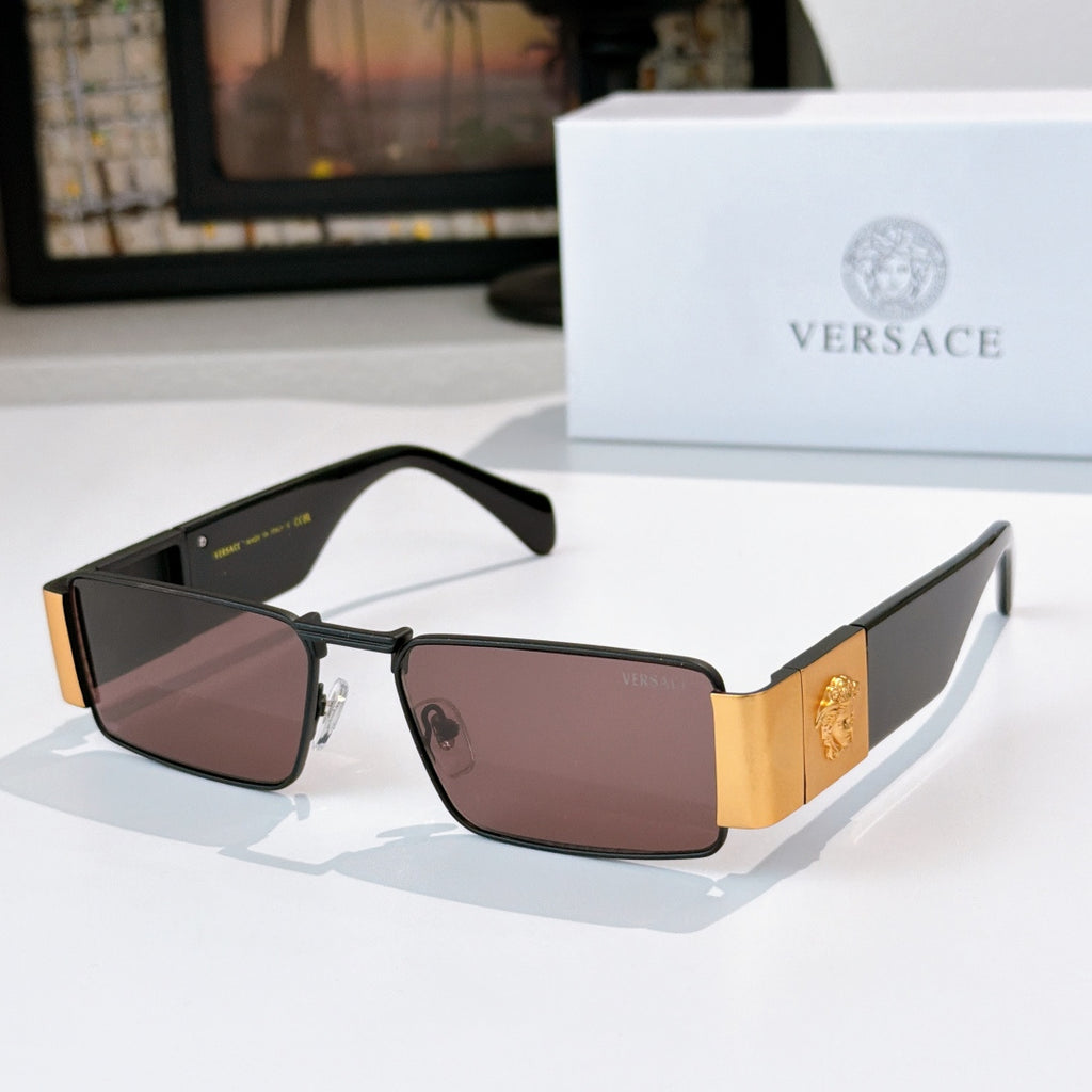 Versace sunglasses with black frames and mauve tinted lenses, gold temple emblem
