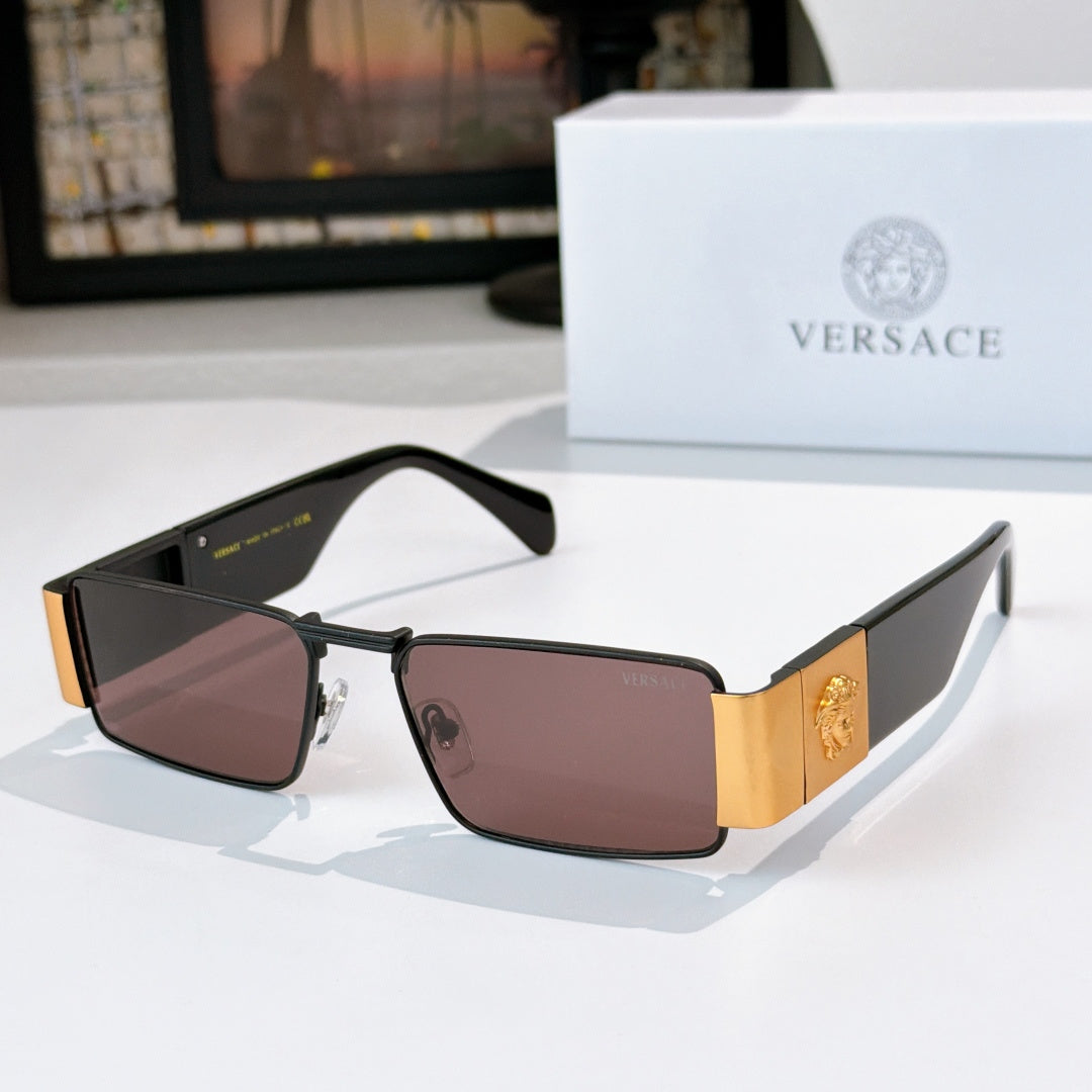 Versace sunglasses with black frames and mauve tinted lenses, gold temple emblem