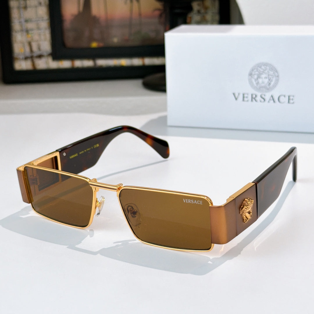 Versace sunglasses with gold frames and amber tinted lenses, lion emblem on temple