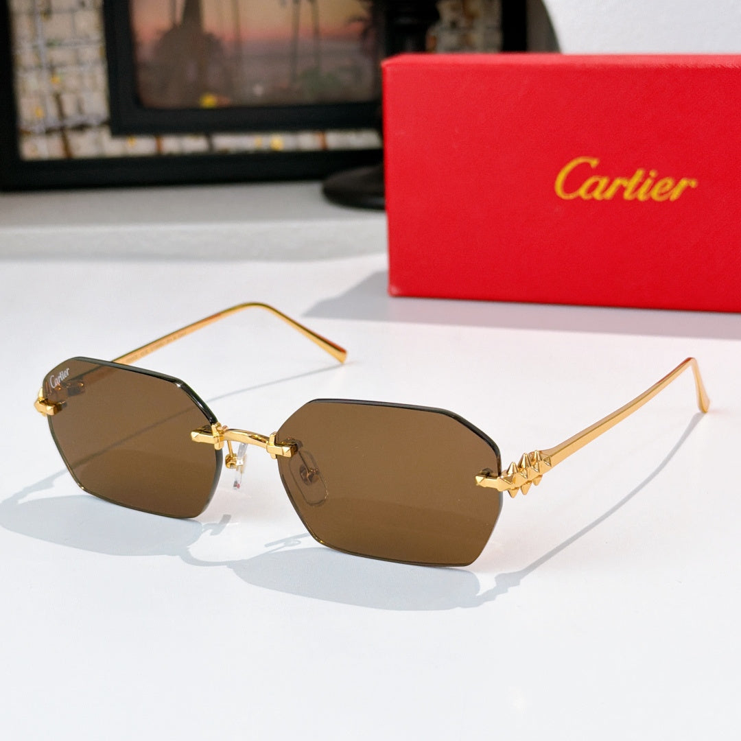 Gold cat-eye sunglasses with brown tinted lenses and ornate metal temple details.