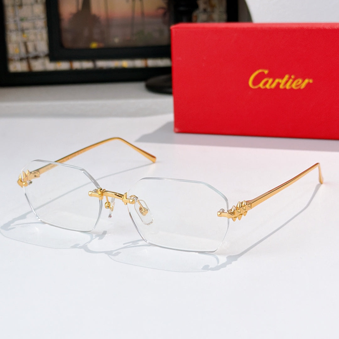 Gold eyeglasses with clear lenses and ornate metal bridge and temple accents.